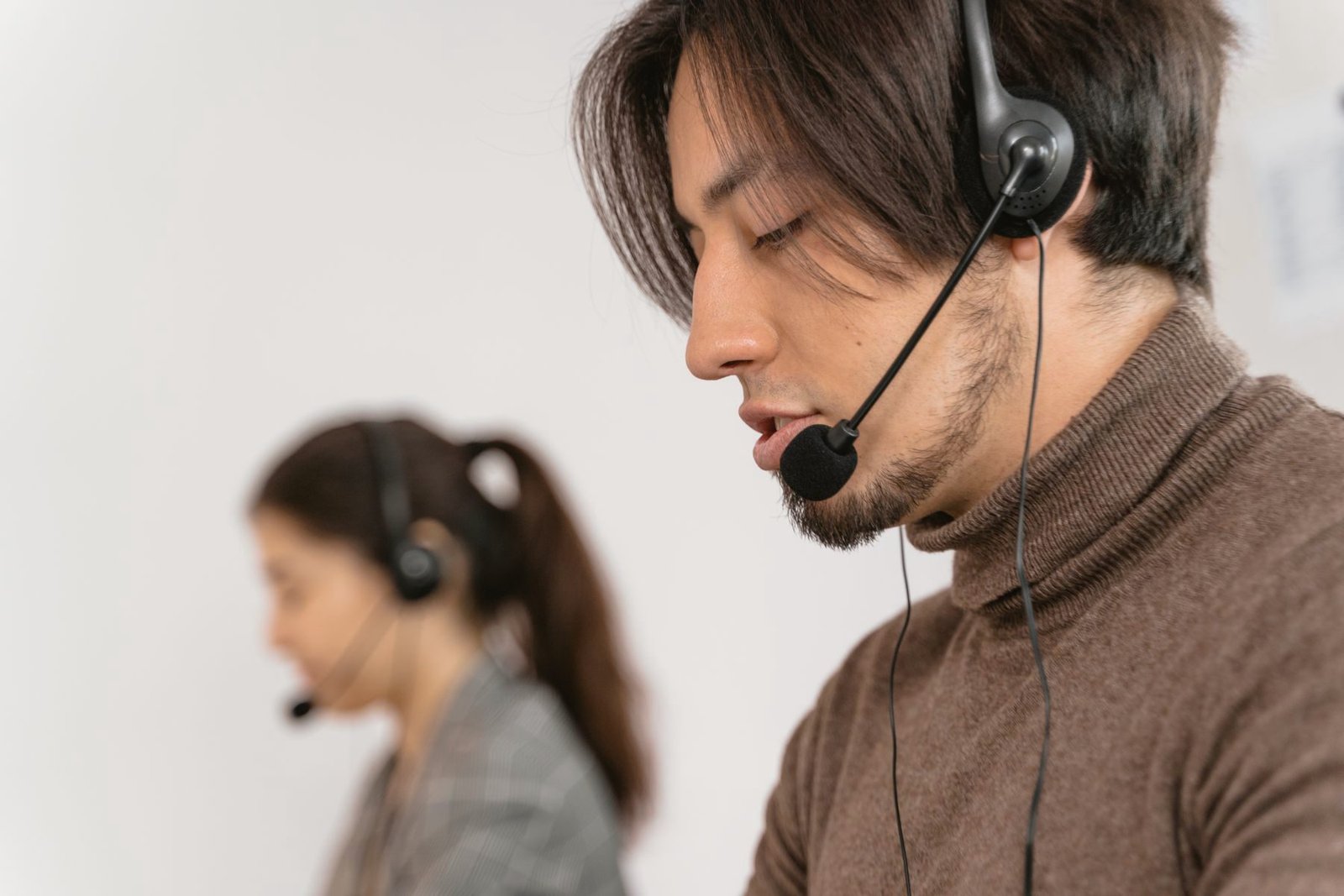 An operator wearing a headset, focused on a call at a computer.