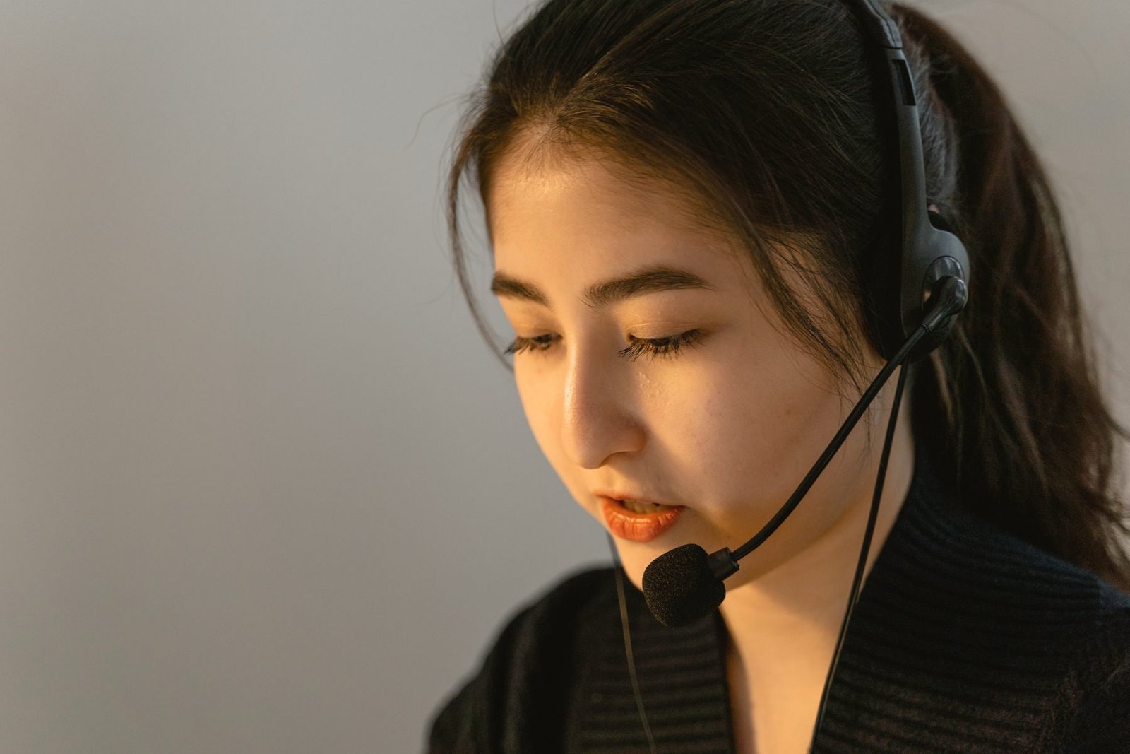 An operator listening carefully on a headset.